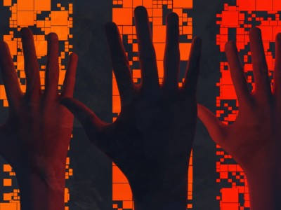 Kolme kättä sormet levällään kämmenselkä kameraa kohti oranssin taustakuvion edessä.