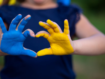 Ukrainan lipun väreillä maalatut kämmenet, jossa sormet muodostavat sydämen.