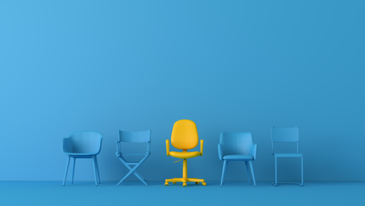 Keltainen tuoli sinisten tuolien joukossa.