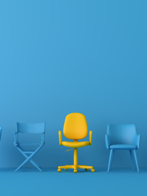 Keltainen tuoli sinisessä huoneessa sinisten tuolien keskellä.