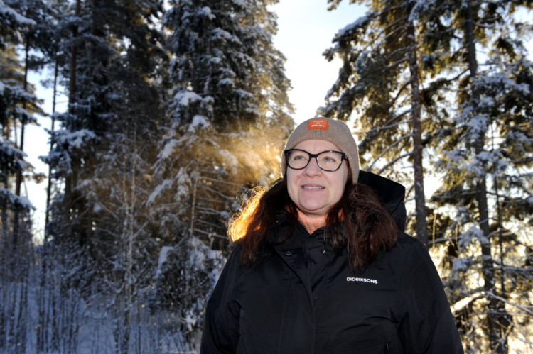Susanna Virtanen talvisessa maisemassa, pään takana auringonsäteitä.