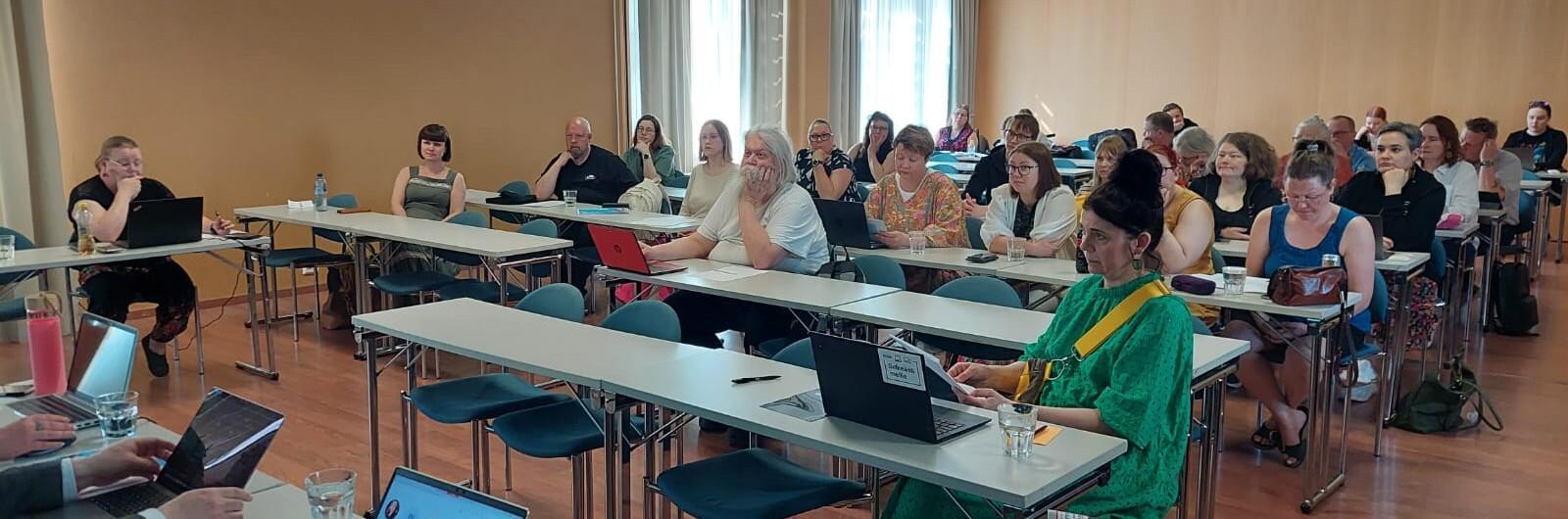 Liittokokousväkeä neuvotteluhuoneessa.