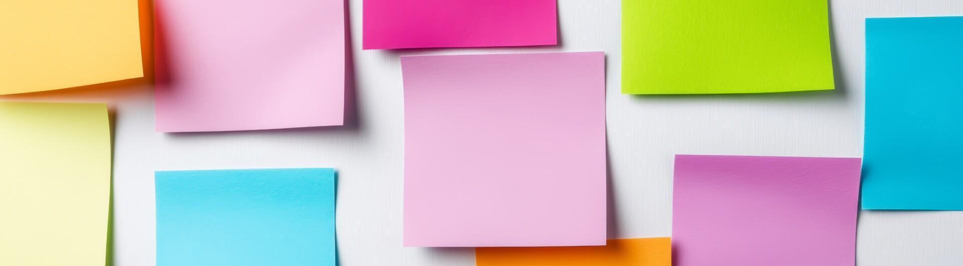 Kuvassa värikkäitä post it -lappuja seinälle kiinnitettynä.