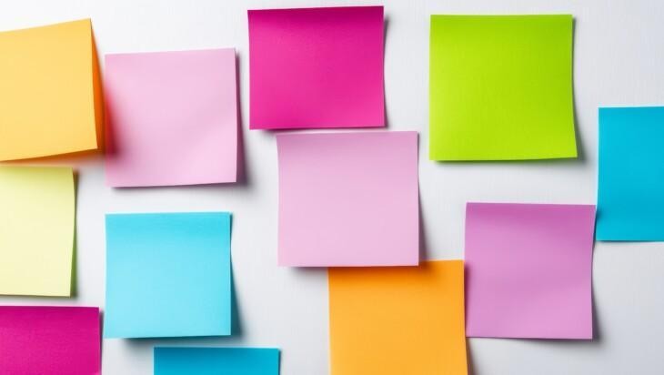 Kuvassa värikkäitä post it -lappuja seinälle kiinnitettynä.