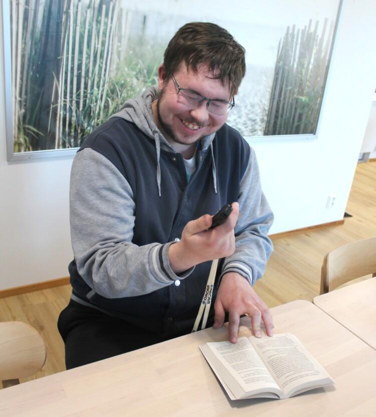 Veikko Pesonen käyttää lukukunäänsä kirjan lukemiseen.