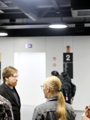 Neljä ihmistä keskustelemassa toistensa kanssa: kaksi naispuolista etualalla, kaksi miespuolista taka-alalla.